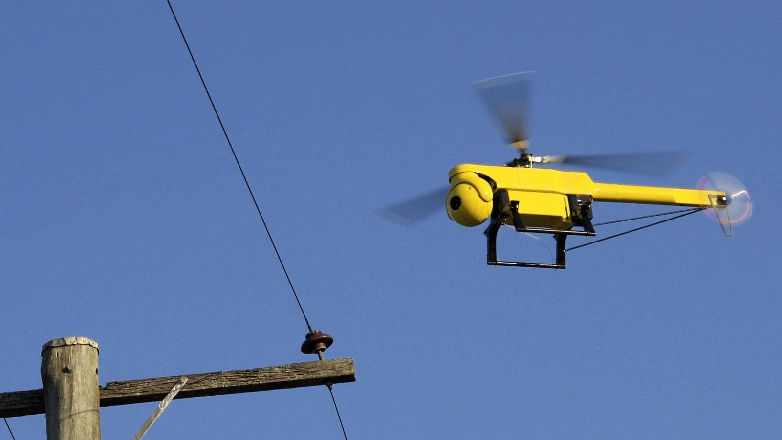 A CSIRO unmanned aerial vehicle flying near an overhead powerline.